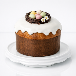 Итальянский панеттоне на пасху (кулич) с белой глазурью и шоколадными яйцами в гнезде