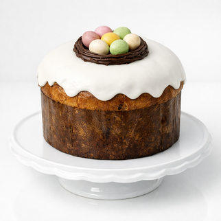 Итальянский панеттоне на пасху (кулич) с белой глазурью и шоколадными яйцами в гнезде