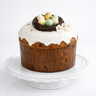 Итальянский панеттоне на пасху (кулич) с белой глазурью и шоколадными яйцами в гнезде