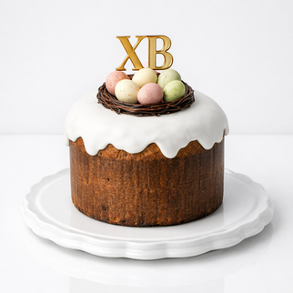 Итальянский панеттоне на пасху (кулич) с белой глазурью и шоколадными яйцами в гнезде ХВ