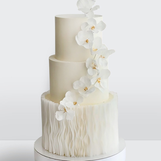 Свадебный торт белый 3 яруса с белыми цветами и оборкой из рисовой бумаги